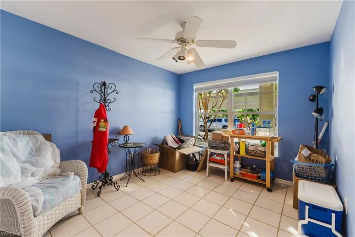 Living area with ceiling fan and light tile patterned flooring