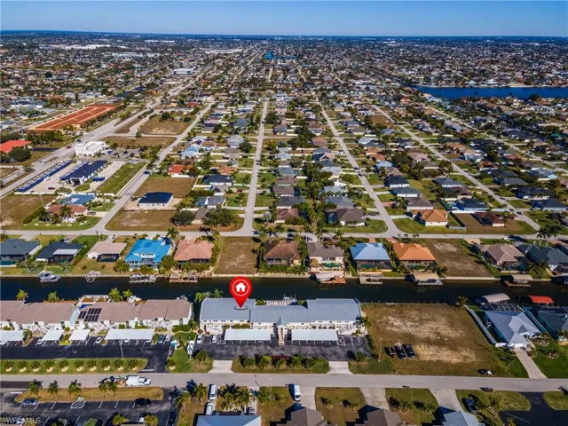Aerial view of property's location featuring a nearby body of water and nearby suburban area