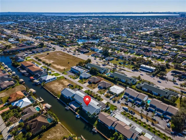 Aerial overview of property's location featuring a large body of water and nearby suburban area