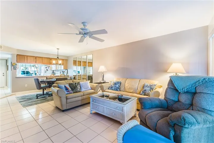 Living area featuring tile patterned flooring, a ceiling fan, and a chandelier