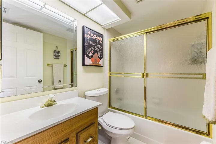 Bathroom featuring vanity and enclosed tub / shower combo