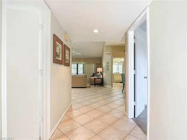 Hall with light tile patterned floors and recessed lighting
