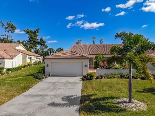 Mediterranean / spanish home featuring driveway, stucco siding, an attached garage, a tile roof, and a front lawn