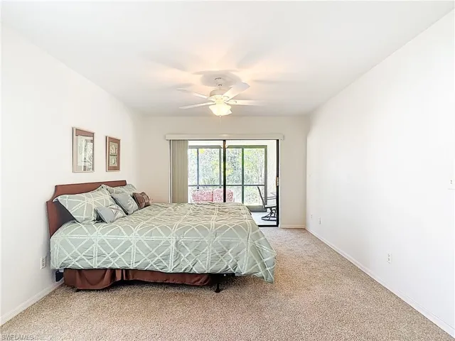 Bedroom with access to outside, a ceiling fan, and carpet