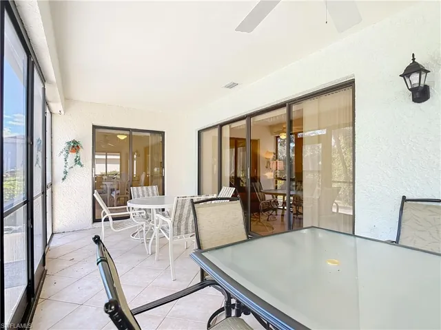 Sunroom / solarium with outdoor dining area and ceiling fan