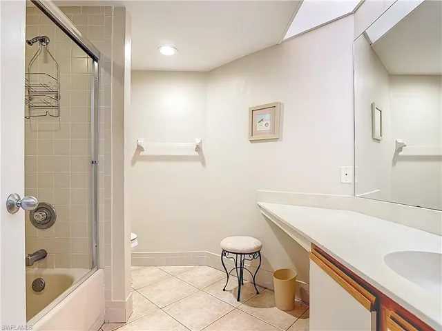 Bathroom featuring vanity, enclosed tub / shower combo, light tile patterned floors, and recessed lighting