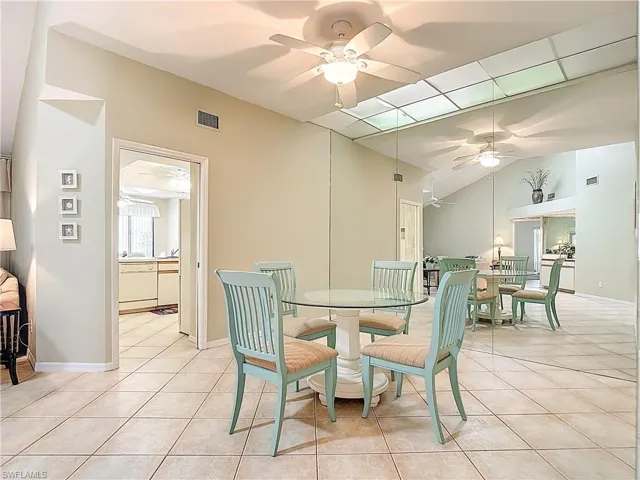 Dining space with light tile patterned flooring, ceiling fan, and lofted ceiling