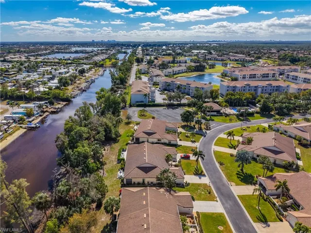 Aerial view of property and surrounding area with a large body of water and nearby suburban area