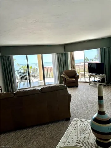 Carpeted living room with a healthy amount of sunlight and a water view
