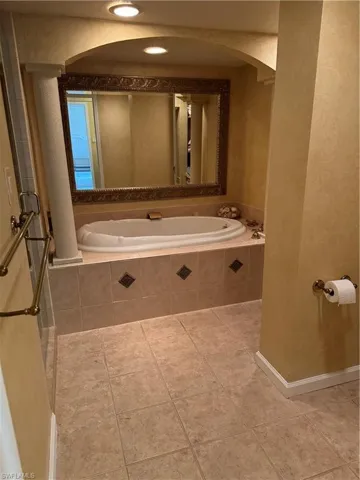 Bathroom with tile flooring and tiled tub
