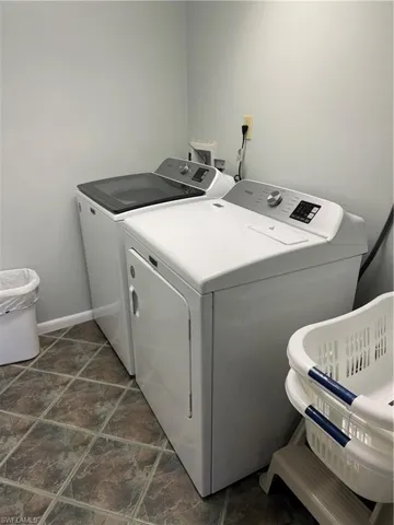 Laundry room featuring independent washer and dryer, dark tile flooring, and washer hookup