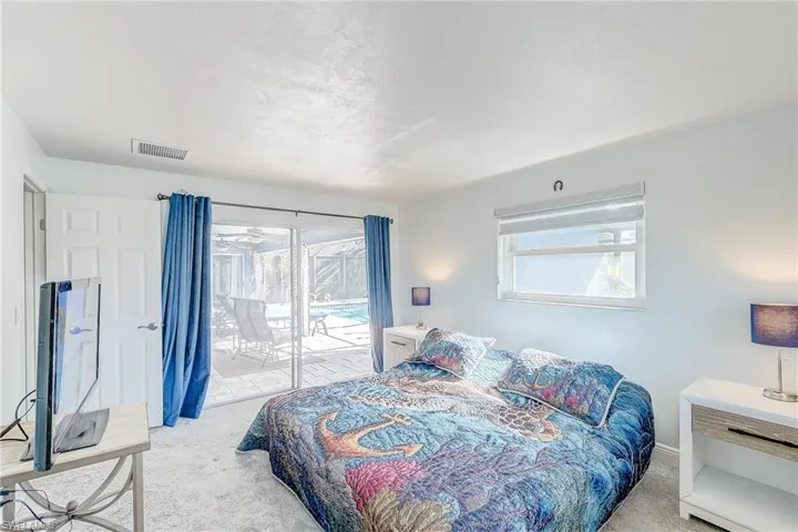 Bedroom with access to exterior and light colored carpet