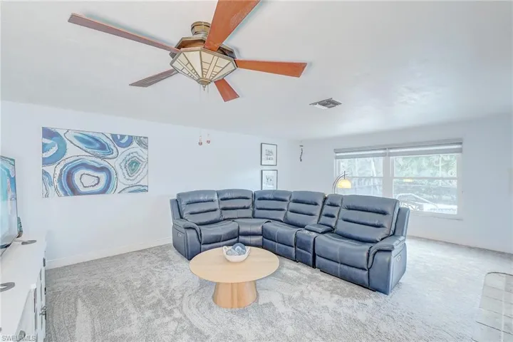Living room with light carpet and ceiling fan