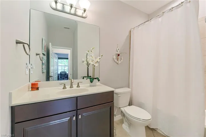 Full bath with vanity and light tile patterned floors