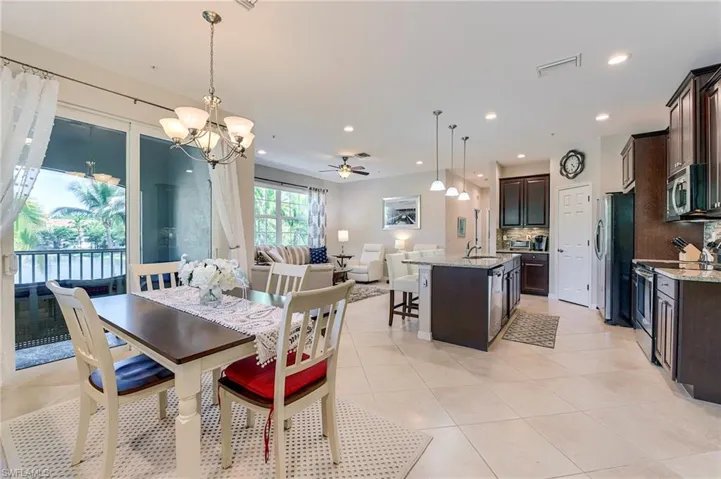 Dining space featuring ceiling fan, a chandelier, light tile patterned floors, and recessed lighting