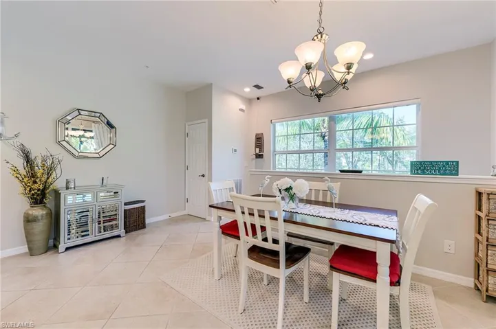Dining space with light tile patterned flooring and a chandelier