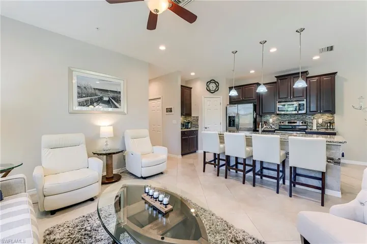 Living area with light tile patterned floors, ceiling fan, and recessed lighting