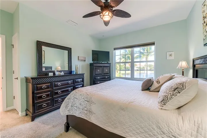 Bedroom with light colored carpet and a ceiling fan