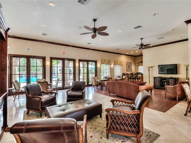 Living room featuring ornamental molding, ceiling fan, recessed lighting, a textured ceiling, and light tile patterned floors