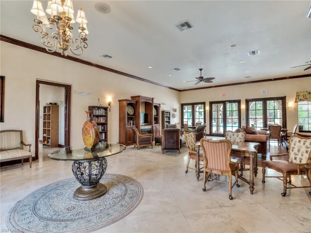 Dining room featuring ornamental molding, ceiling fan, and a chandelier