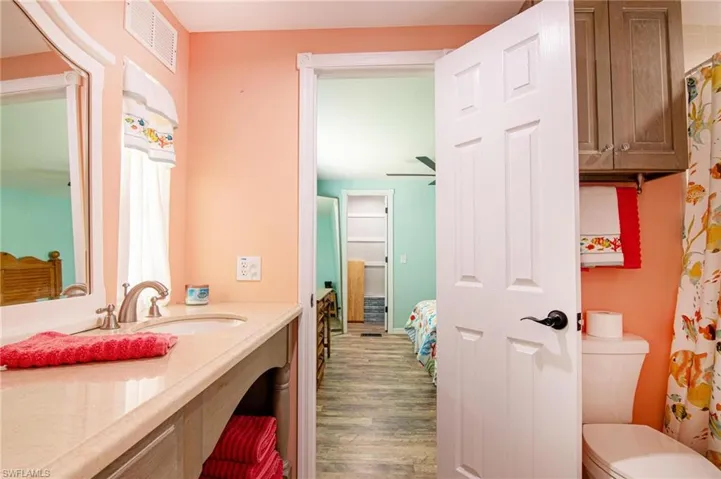 Bathroom with vanity, hardwood / wood-style floors, and toilet
