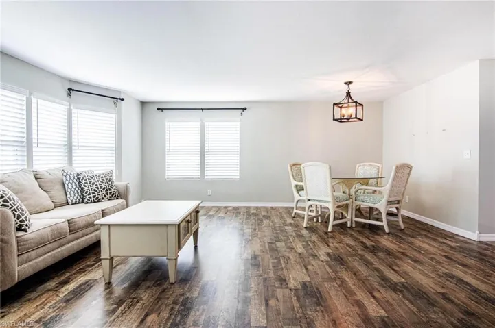 Living room with dark wood-type flooring and a chandelier