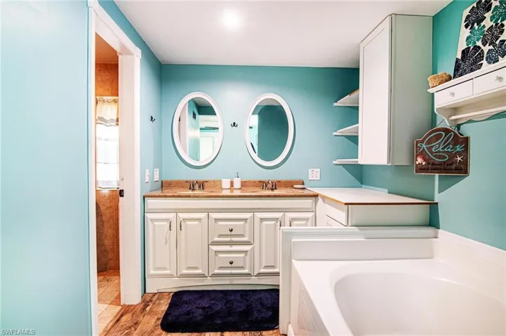 Bathroom with hardwood / wood-style flooring, vanity, and a bathing tub