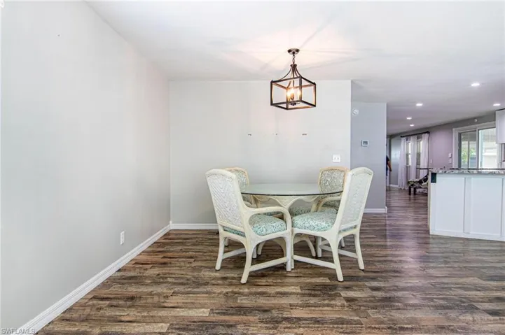 Dining area with dark wood-type flooring and a chandelier