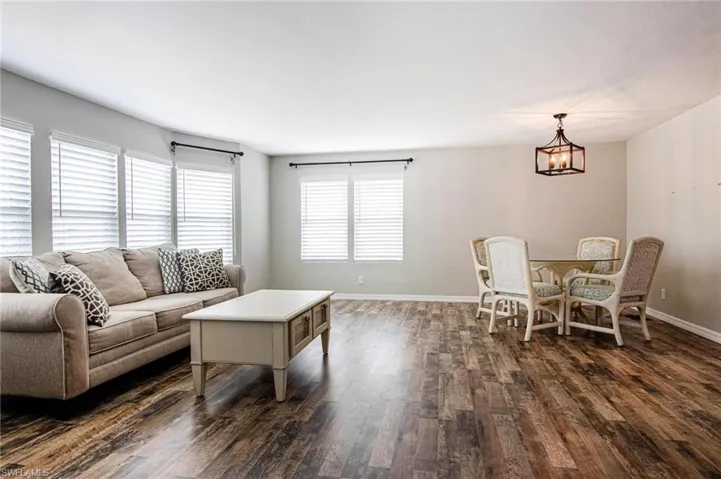 Living room featuring a notable chandelier and dark wood-type flooring