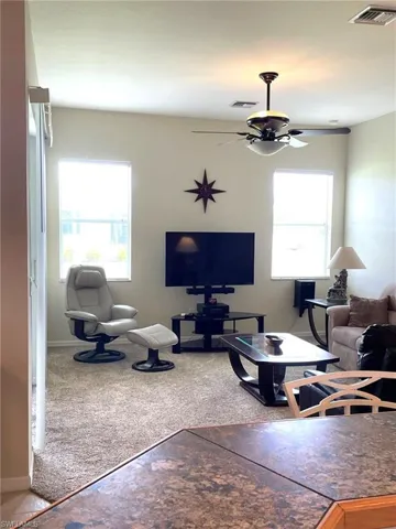 Living room featuring ceiling fan and carpet floors