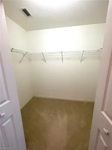 Bedroom 1 - Walk in closet featuring light colored carpet