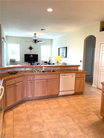 Kitchen with dishwasher, ceiling fan, sink, and light tile patterned floors