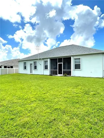 Rear view of property with a sunroom and a yard