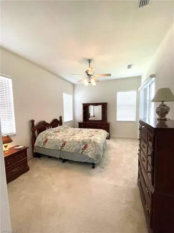 Bedroom #1 with sliders to lanai, carpeting, ceiling fan