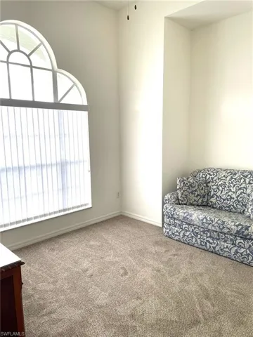 Carpeted den with sunburst window that attaches to Bedroom one.  Perfect flex room!