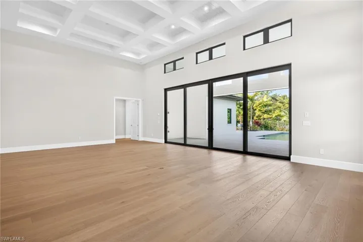 The large great room with open an concept family style design is bright and airy ,lovely wood floors, plenty of natural lighit flows through the sliding glass doors
