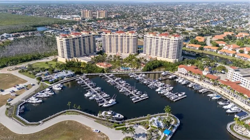 Drone / aerial view of numerous boat docks and a nearby body of water
