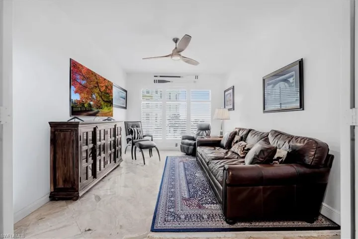 Living area with light marble finish floors and a ceiling fan