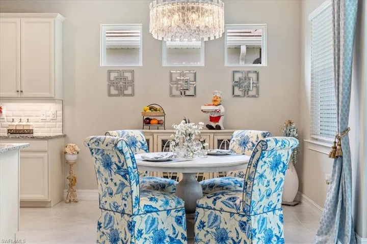 Tiled dining space with an inviting chandelier and plenty of natural light