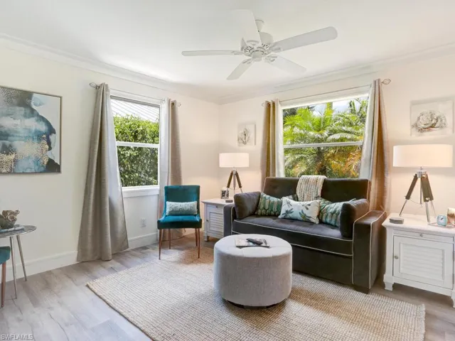 Sitting room featuring light wood-type flooring, crown molding, and a ceiling fan