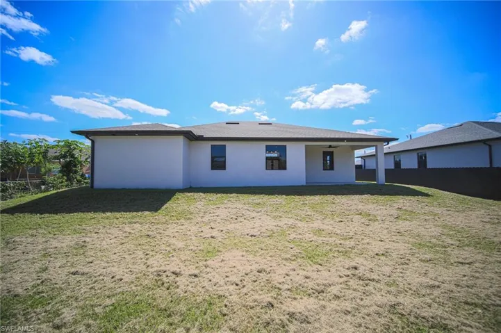 Back of house featuring a patio area, a ceiling fan, stucco siding, and a fenced backyard