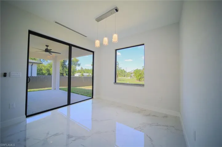 Unfurnished dining area with marble tiled flooring and a ceiling fan