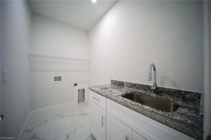 Laundry room with light marble finish floors, electric dryer hookup, cabinet space, and hookup for a washing machine