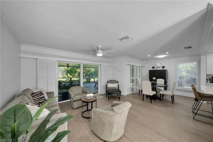 Open-concept interior featuring light wood-finish flooring, white crown molding, and recessed lighting