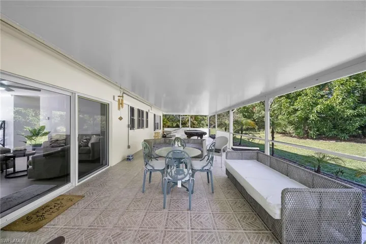 Expansive covered patio featuring a white ceiling and patterned tile flooring