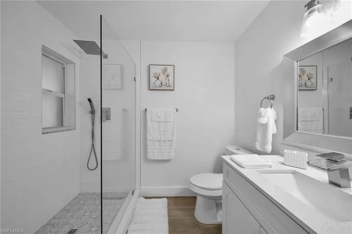 Contemporary bathroom featuring a frameless glass shower enclosure with a rain shower head and handheld sprayer