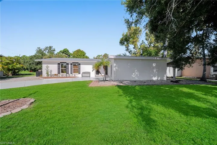 Single-story residence featuring a gray roofline, white exterior, and dark window shutters