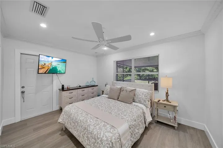 Bright interior space featuring wood-finish flooring, recessed lighting, and crown molding