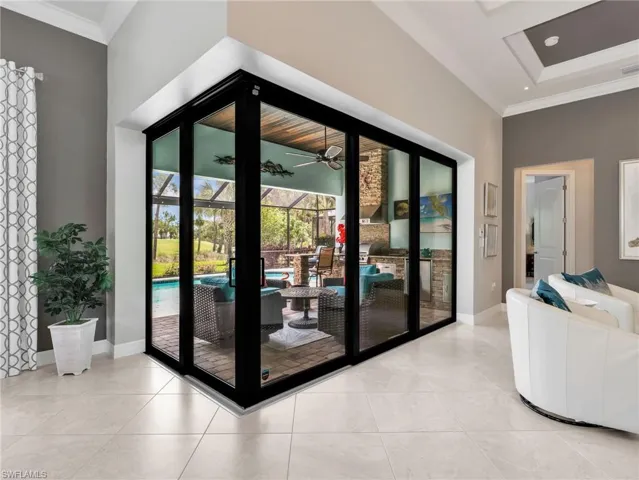 Zero Corner Slider Leading Onto the Screened-In Lanai with Paver Flooring & Pool Deck (Doors Closed)