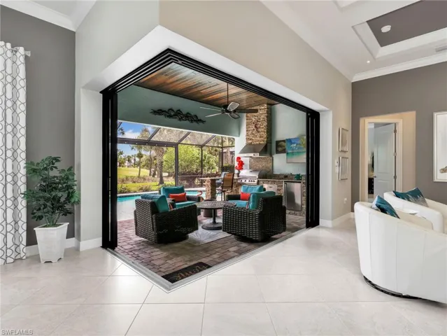 Zero Corner Slider Leading Onto the Screened-In Lanai with Paver Flooring & Pool Deck (Doors Open)